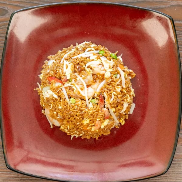 Shrimp fried rice with bean sprouts, peas, and egg, served on a square red plate.